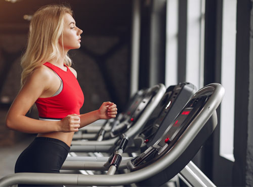 Sports blonde woman in a sportswear training in a gym