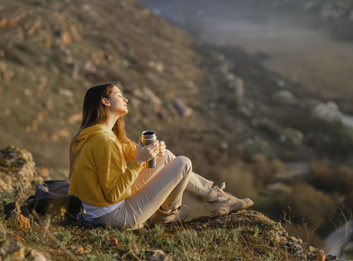 Long shot of young woman enjoying the nature around her