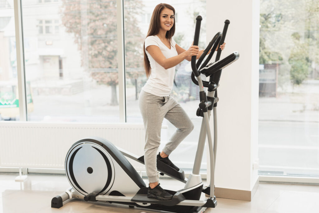 girl doing exercise on Elliptical at home 