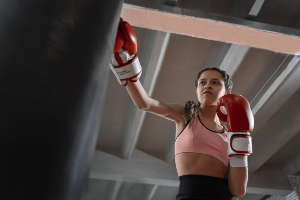 girl doing exercise on Boxing punching bag at home 